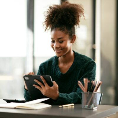 African american student woman in sweater writing information an